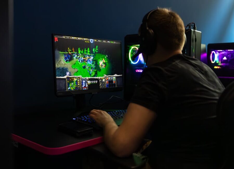 Obraz z obozu e-sportowego, mężczyzna przy komputerze grający w Warcrafta