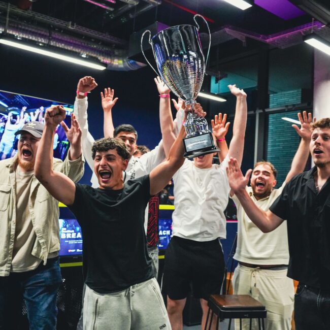 Winning team holding up trophy at BaseStack BREACH event, esports gaming venue in central dortmund