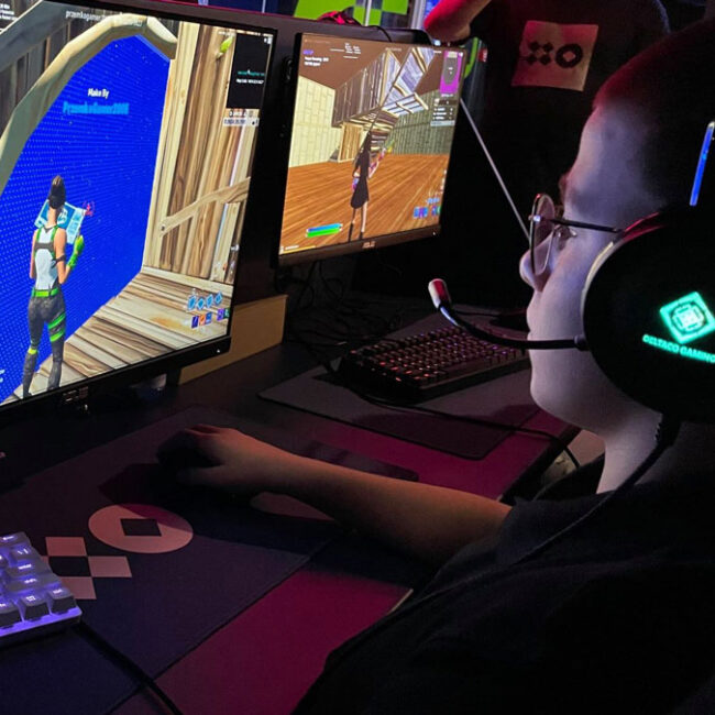 Ein junger Gamer mit Brille spielt Fortnite.