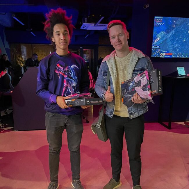 Two gamers holding their boxed peripherals for the camera.
